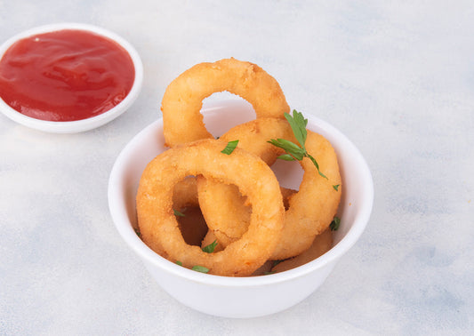 Delicious Crispy Golden Battered Onion Rings served as a starter at Heeran Al Dar Cafeteria, perfect for snacking or sharing as fried appetizers.