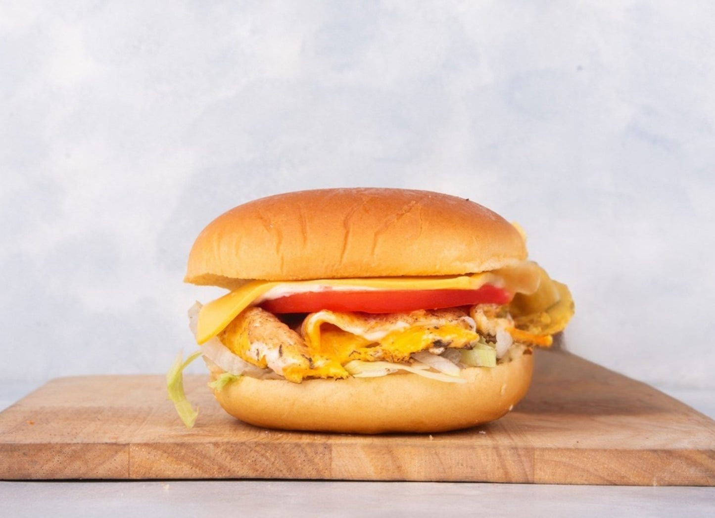 Delicious Fried Egg Burger from Heraan Al Dar Cafeteria, showcasing a perfect combination of fresh ingredients including a perfectly fried egg, crisp lettuce, juicy tomatoes, and creamy cheese, ideal for any meal.