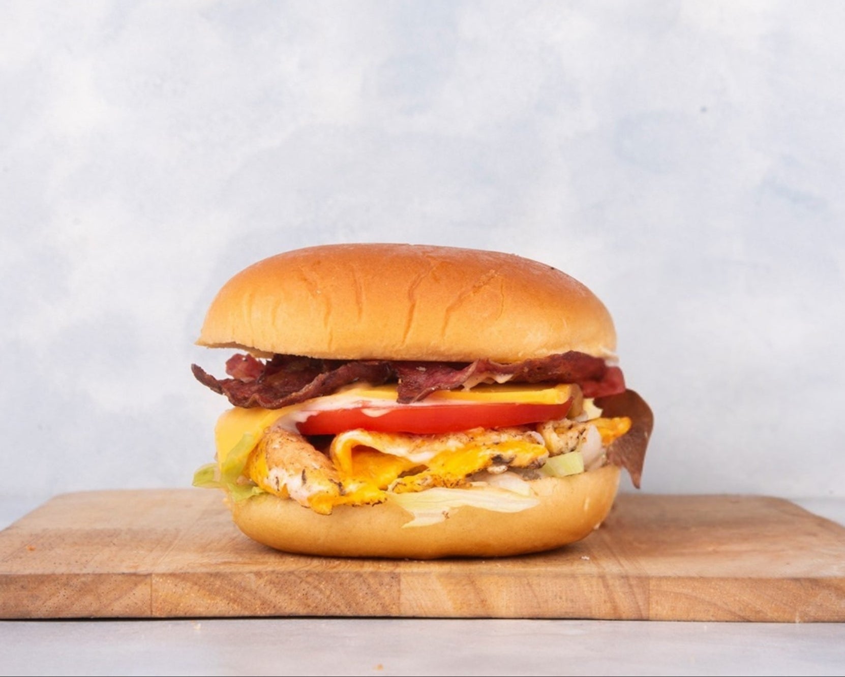 Delicious Fried Egg Burger with Beef Bacon from Heraan Al Dar Cafeteria, featuring a perfectly fried egg, crispy beef bacon, and fresh ingredients. This mouthwatering burger showcases the rich flavors and textures, making it a standout choice for burger lovers.